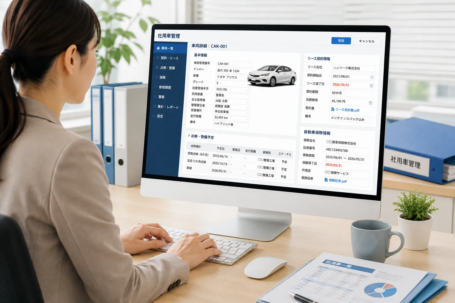 総務担当者がパソコンから社用車の基本情報、リース契約、点検予定、保険情報を登録する様子
